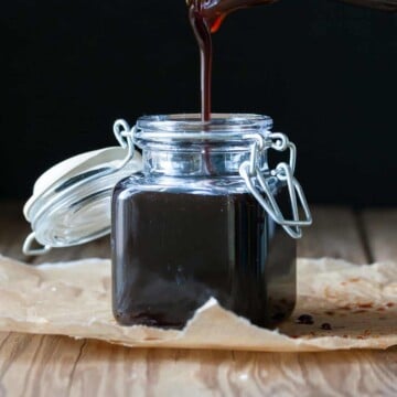 Glass jar filling with poured teriyaki sauce