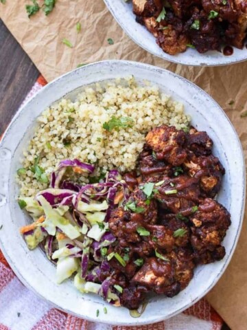 Bbq cauliflower bites with cabbage and quinoa in a white bowl