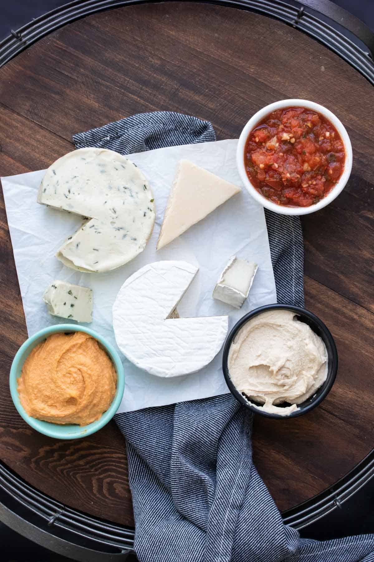 Piece of parchment with cheese on top next to bowls of dips