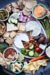 Photo of a charcuterie spread with veggies, crackers, nuts, cheeses and other things crammed close together.