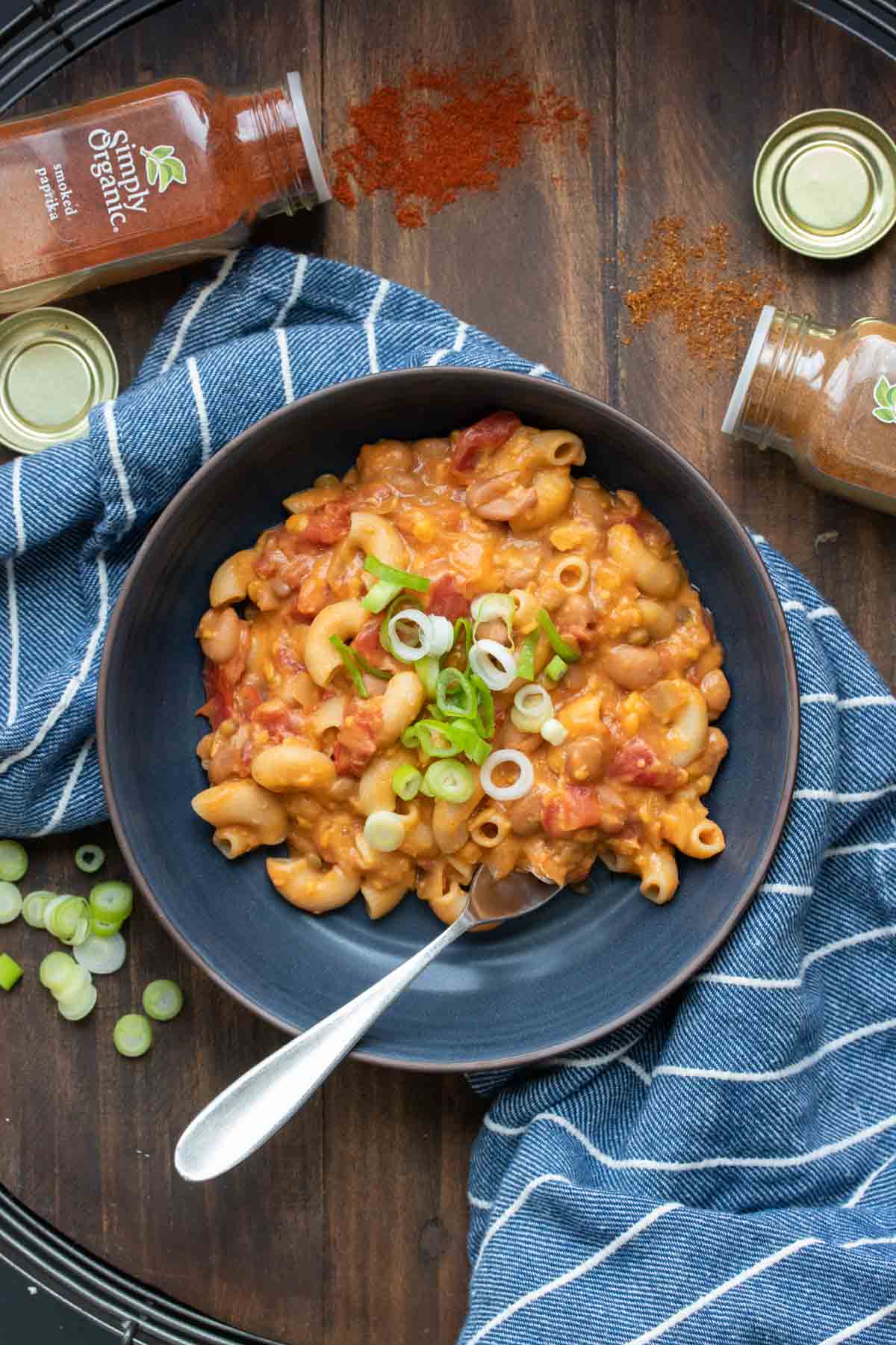 Top view of a black bowl filled with chili mac and cheese and a fork in it