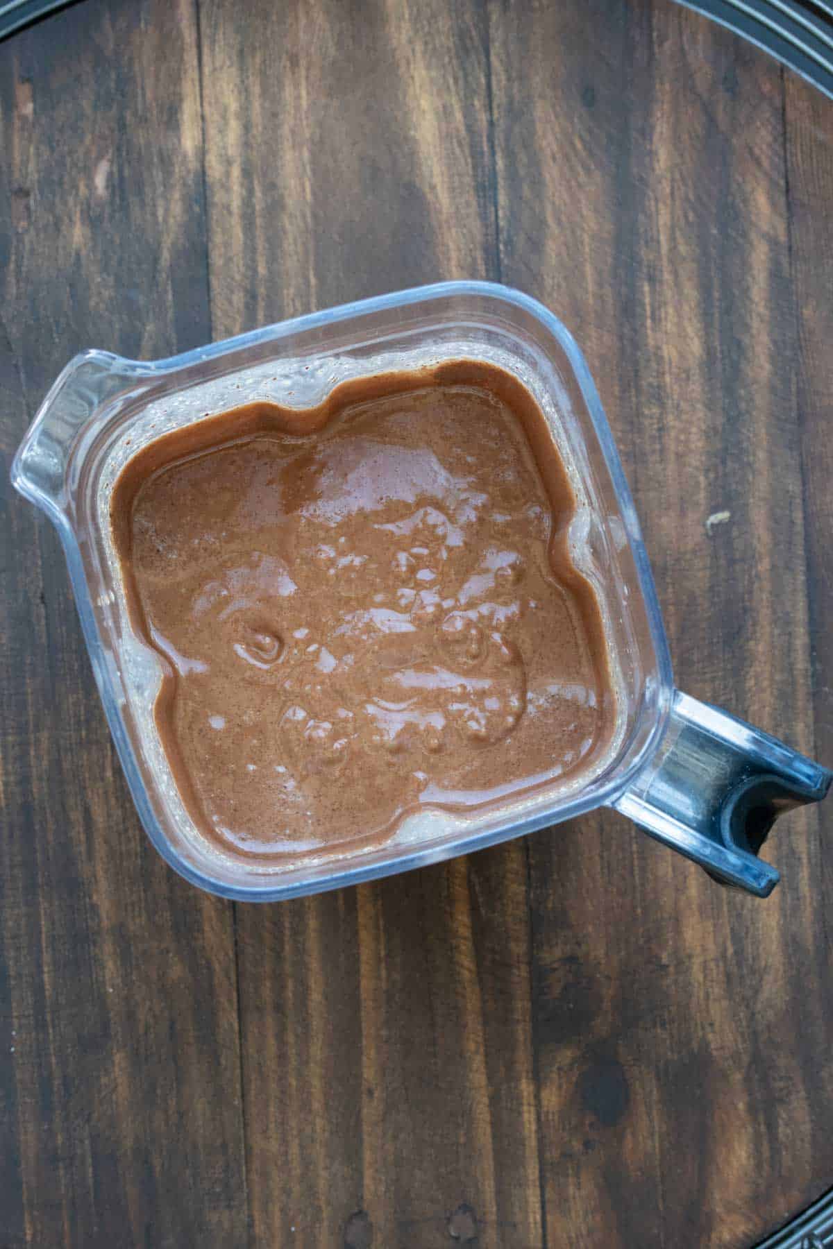 Top view of a blender with chocolate ice cream liquid base inside