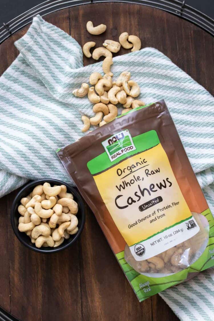 Tüte mit Cashewnüssen, die auf einem gestreiften Handtuch liegen