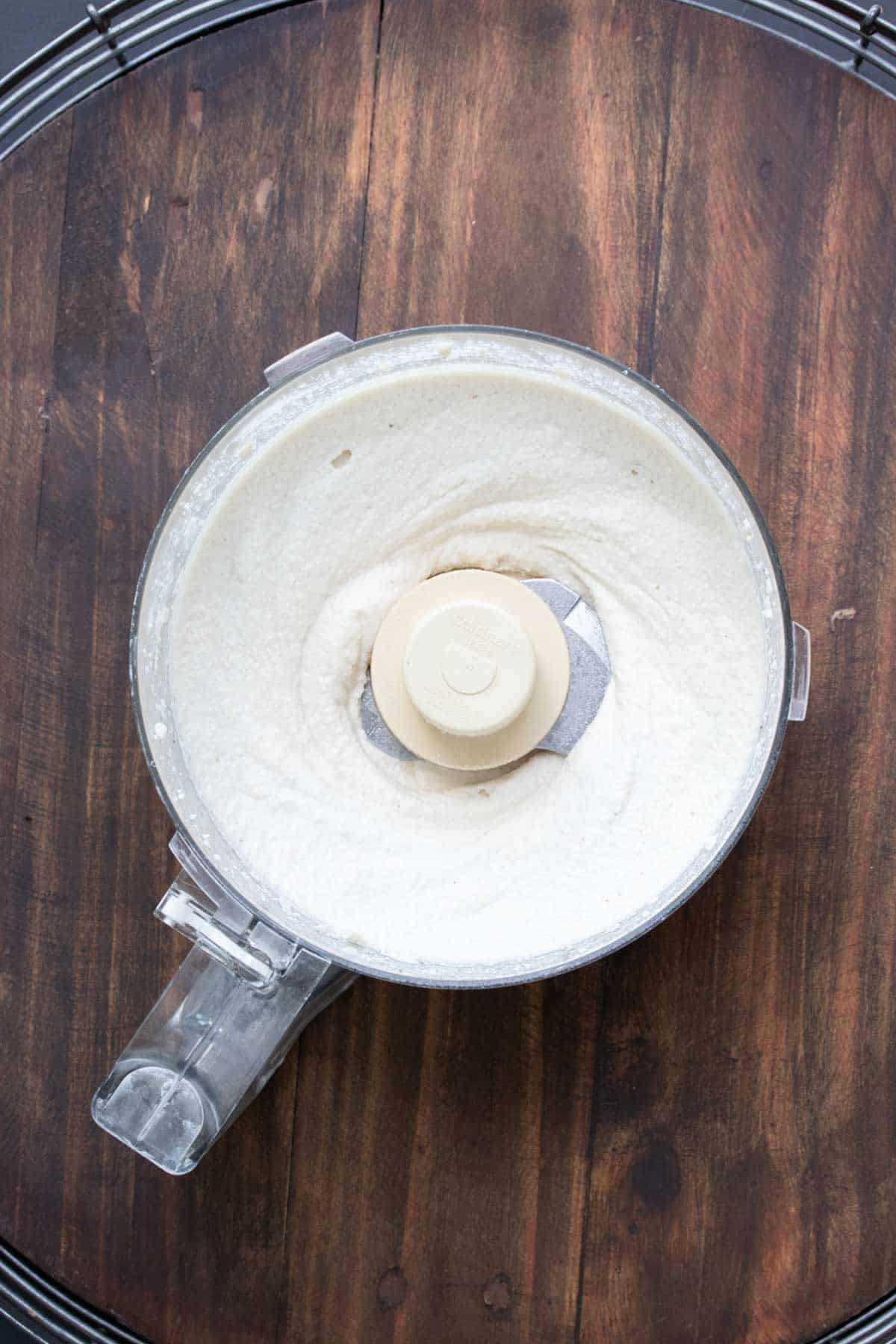 Top view of a food processor with creamy mascarpone in it.
