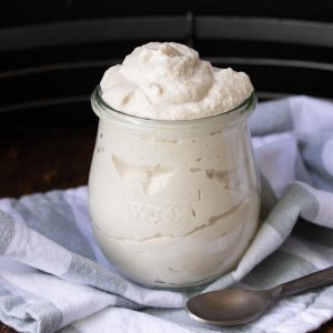 Close up of a glass jar filled with mascarpone cheese.