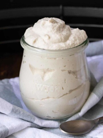 Close up of a glass jar filled with mascarpone cheese.