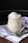 A glass jar filled with mascarpone cheese sitting on a wide blue and white striped towel.