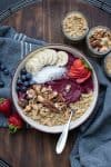 Eine Smoothie Bowl in einer Cremeschale mit Früchten und Nüssen