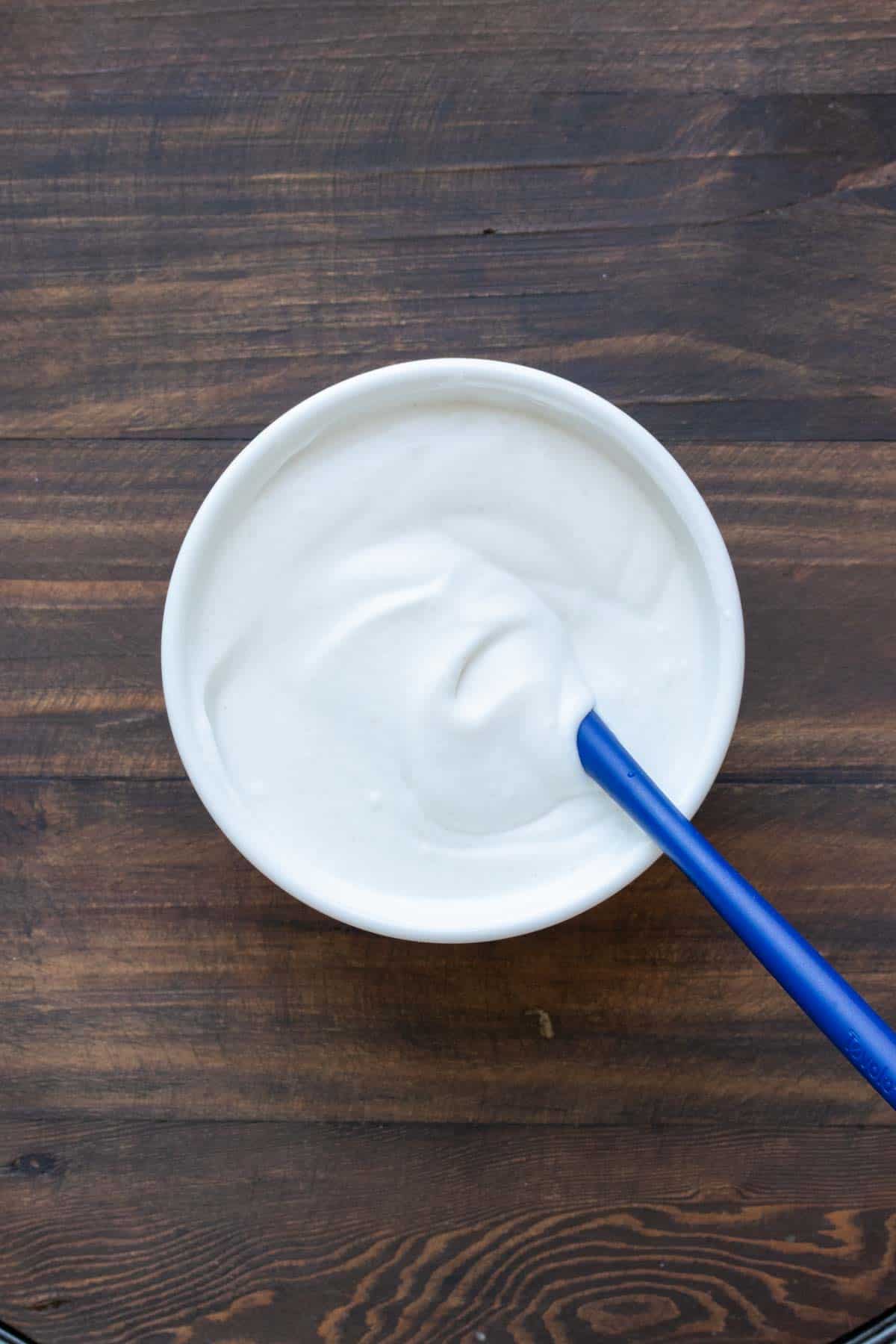 Top view of a white bowl filled with whipped cream