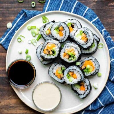 Cream plate with cut vegetable sushi and dipping sauces on it