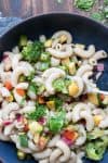 Fork getting a bite of pasta salad from a black bowl