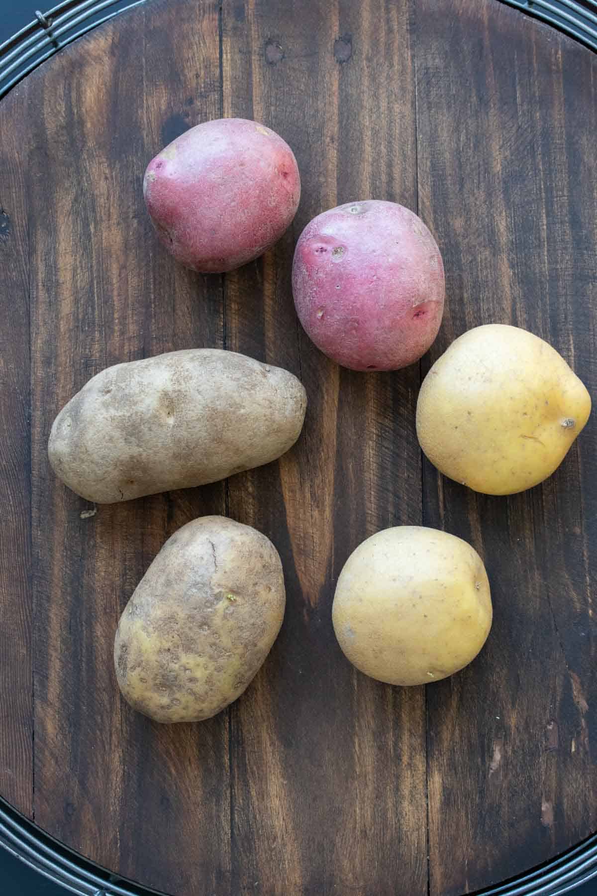 Top view of different kinds of potatoes on a wooden table