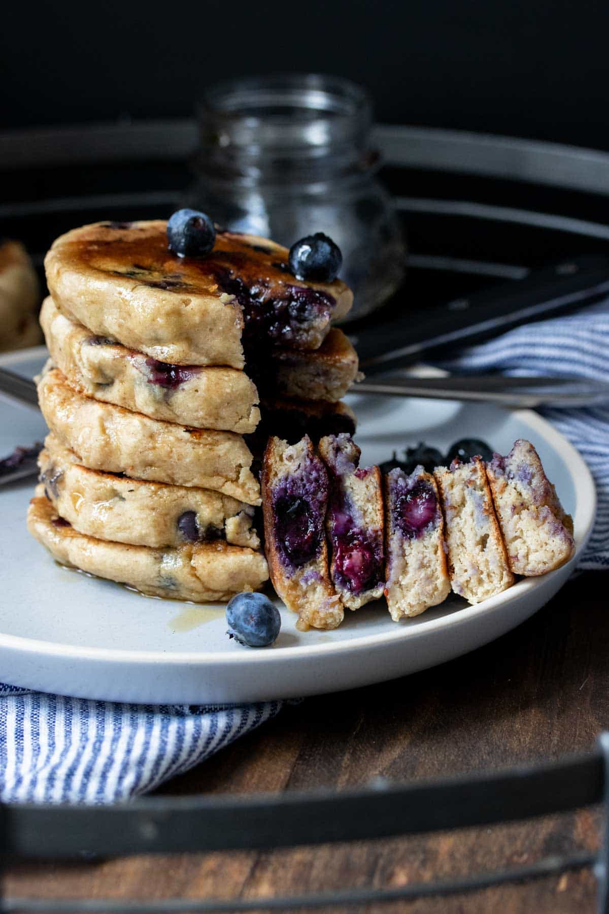 A cut out bite of blueberry pancakes from a stack of them