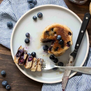 Top view of blueberry pancakes with a cut out bite next to it