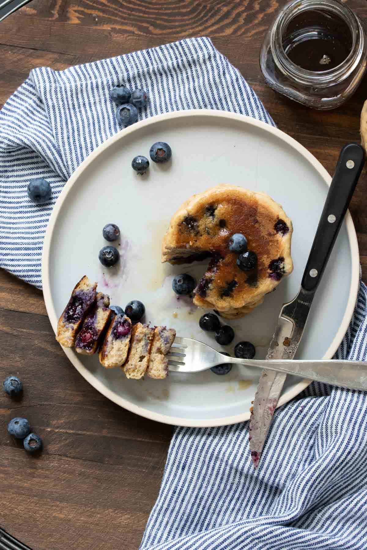 Top view of blueberry pancakes with a cut out bite next to it