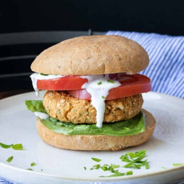 Chickpea burger on a bun with lettuce tomato and sauce dripping