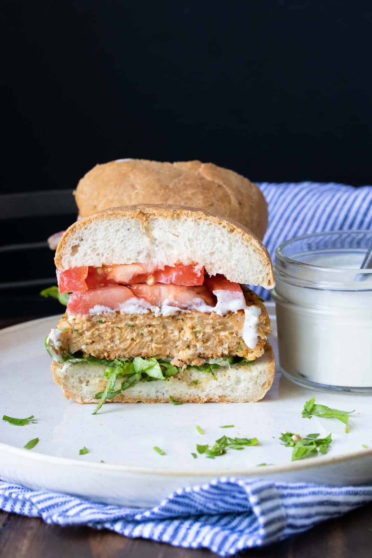 Half of a chickpea burger with lettuce, tomato and dripping sauce