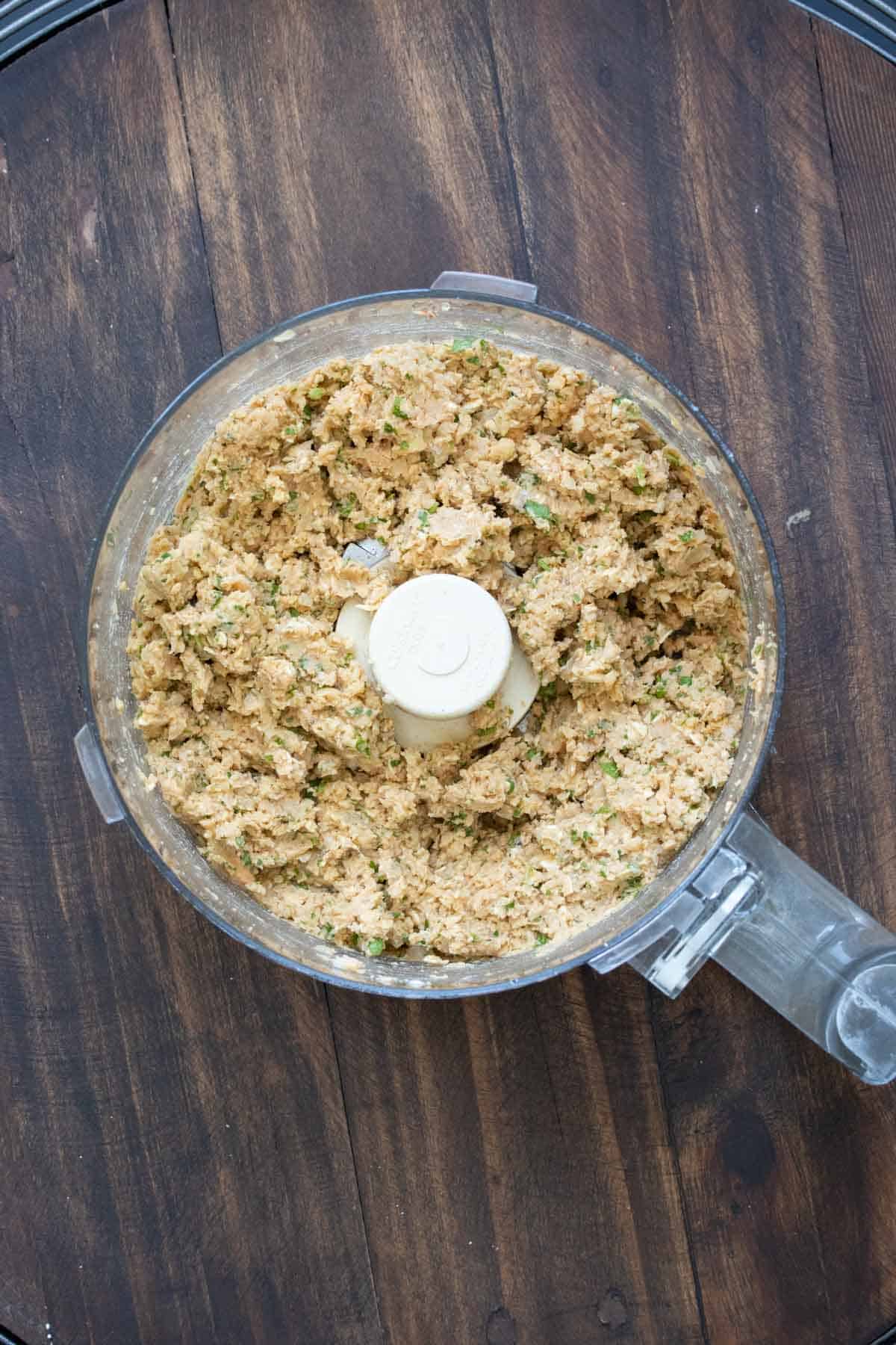 Top view of a food processor with veggie burger mixture.