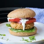 White plate with a chickpea burger on a bun.