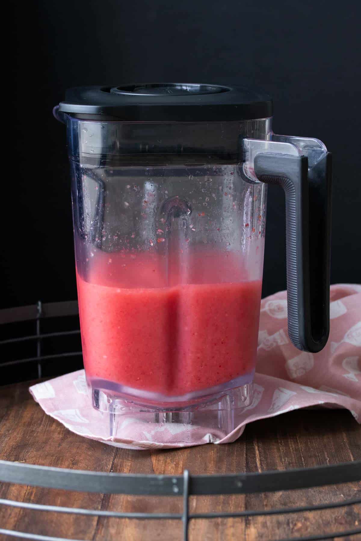 Blender filled with a bright pink frozen mixture.