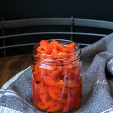 Glass jar with sliced roasted red peppers inside