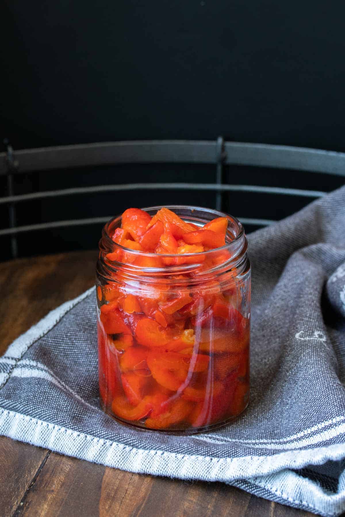 Glass jar with sliced roasted red peppers inside