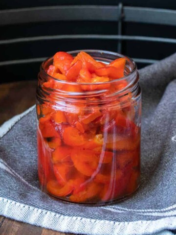 Sliced roasted red peppers in a glass jar