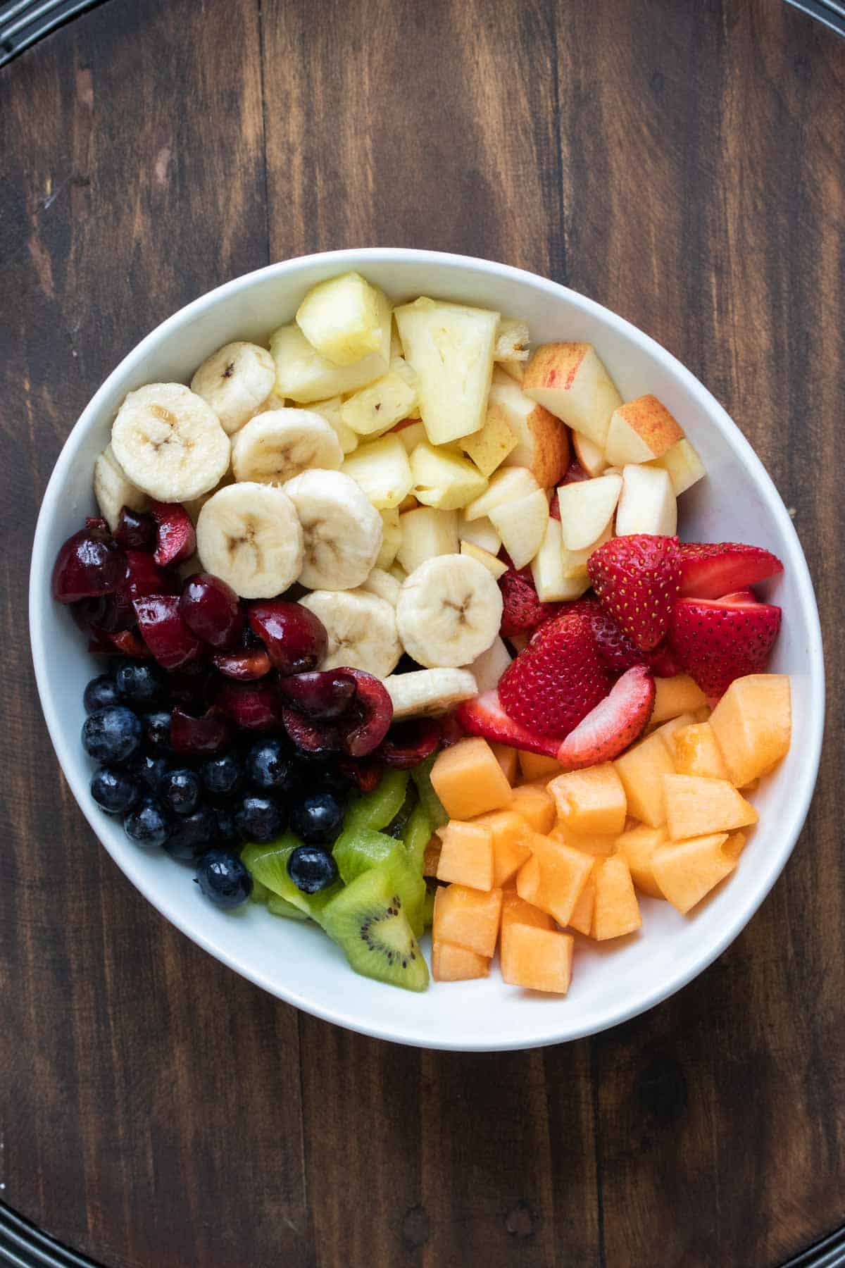 White bowl with sections of cut up fruit