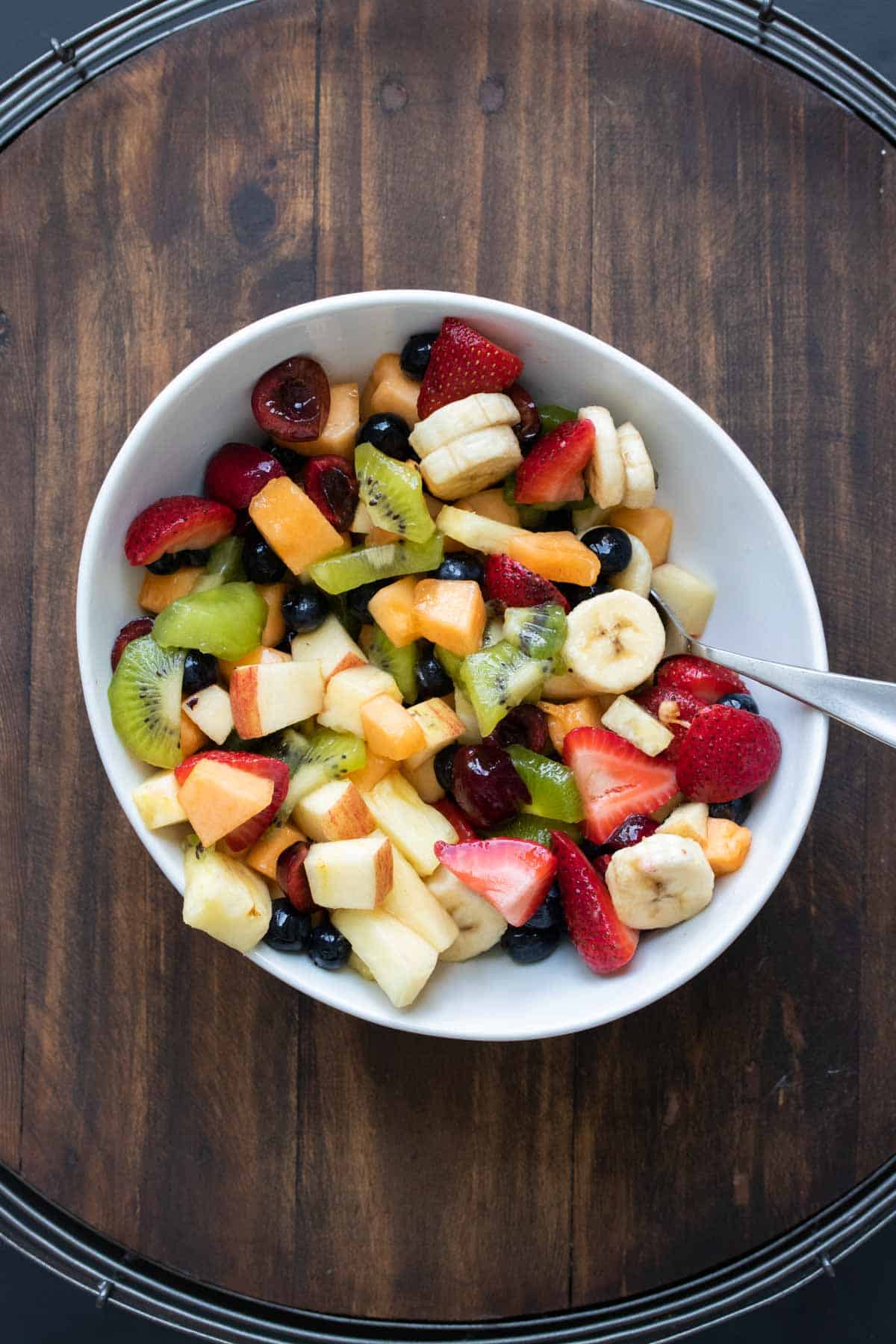 Variety of cut up fruit in a white bowl