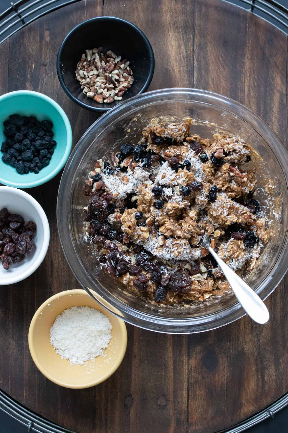 Glass bowl filled with oat cookie mixture with dried blueberries and coconut