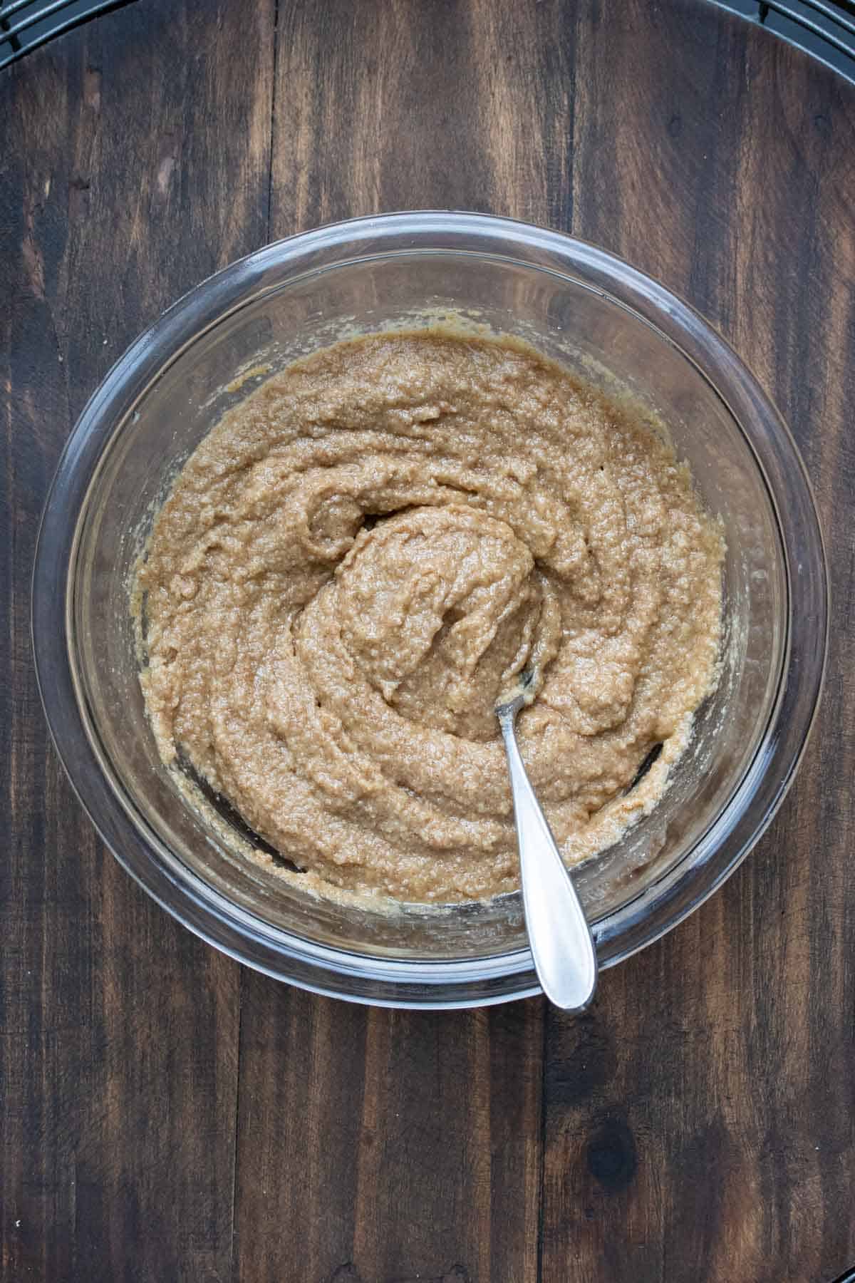 Spoon mixing wet baking mixture in a glass bowl