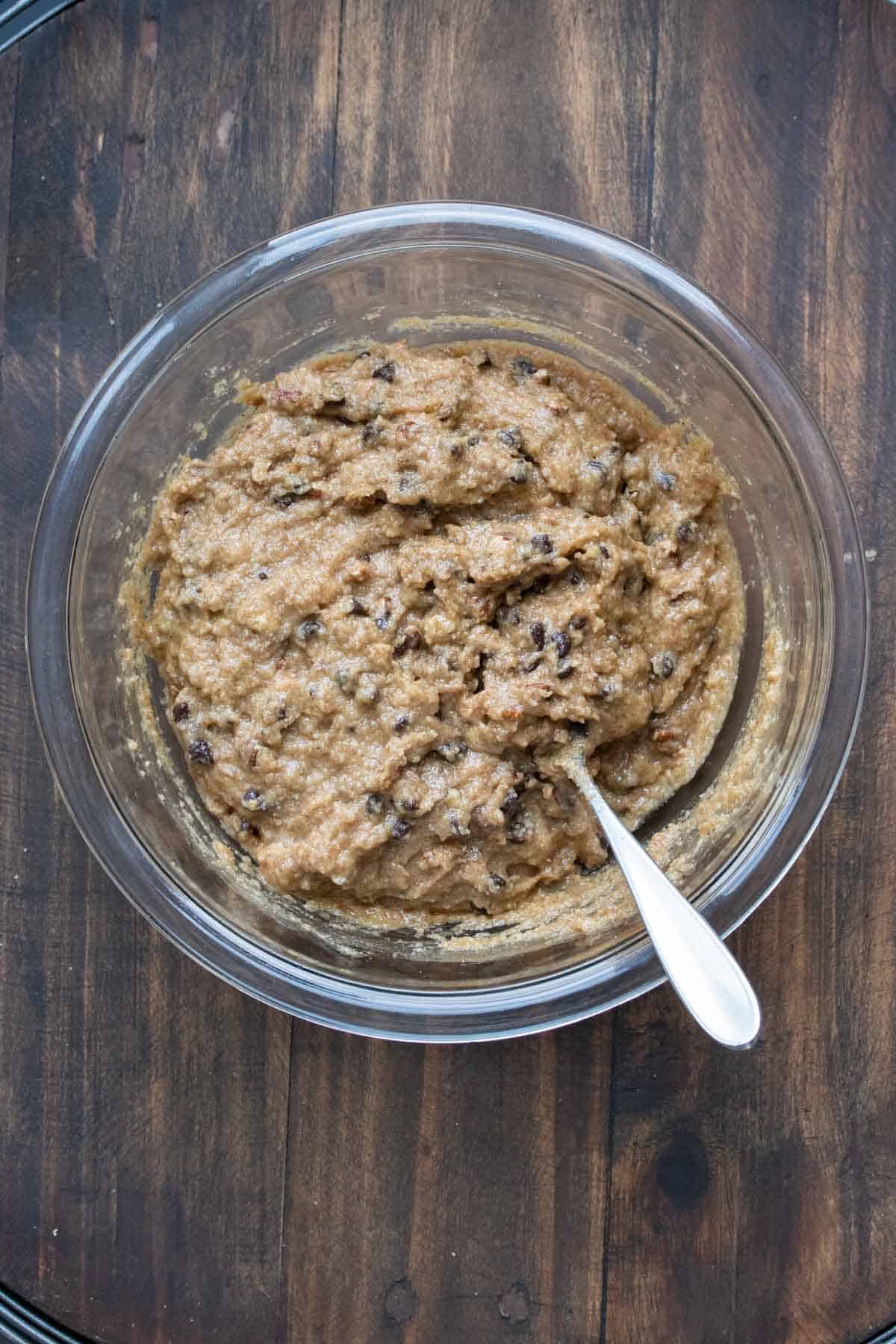 Chocolate chip cookie dough in a glass bowl with a spoon