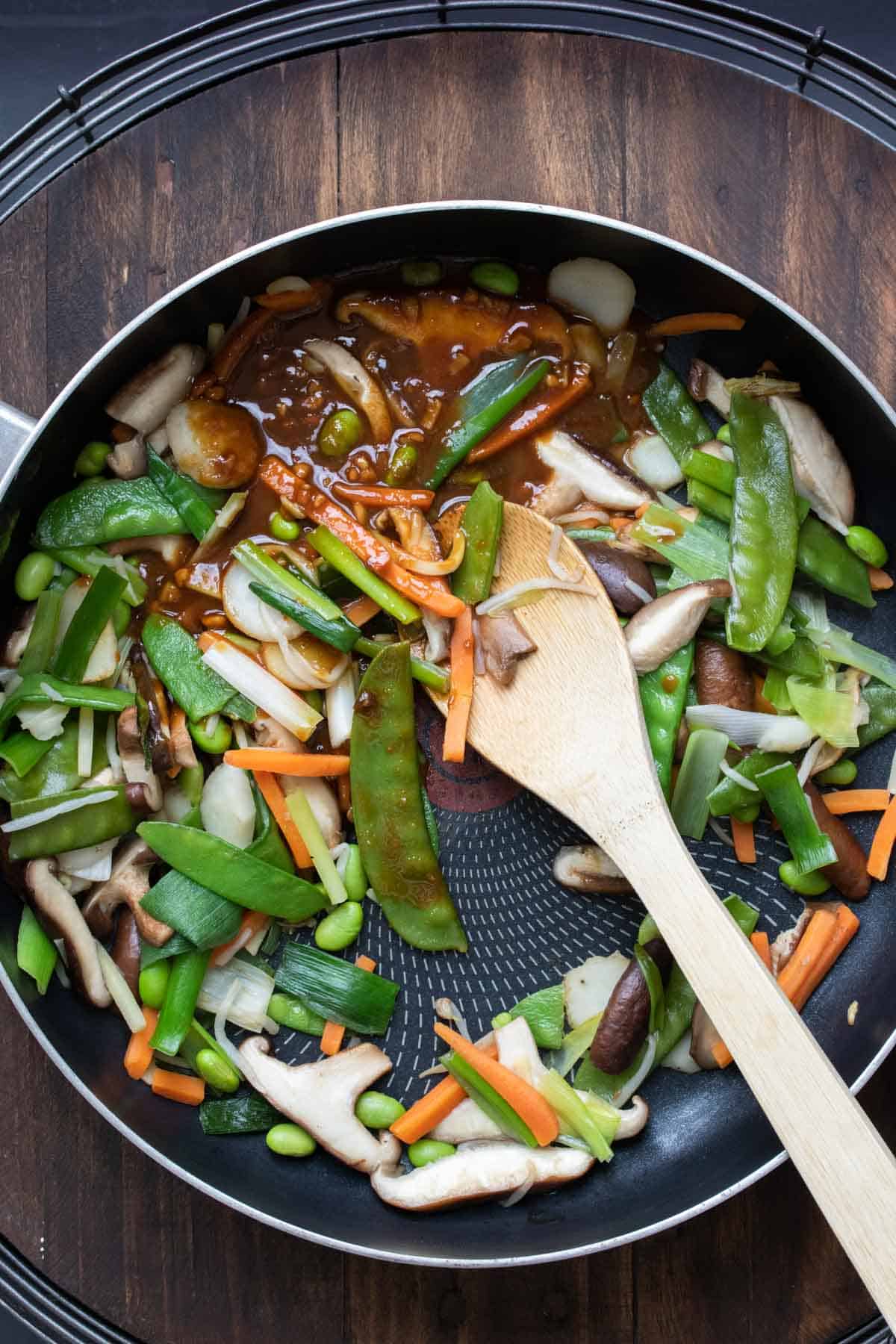 Brown sauce mixing into a pan full of veggies