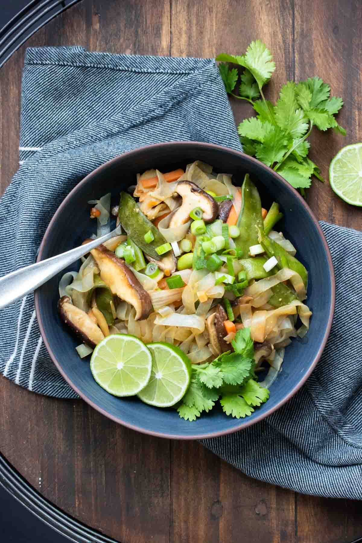 Dark blue bowl with stir fry noodles and veggies inside