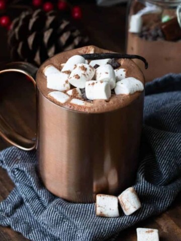 A photo of brown mug with hot cocoa topped with marshmallows