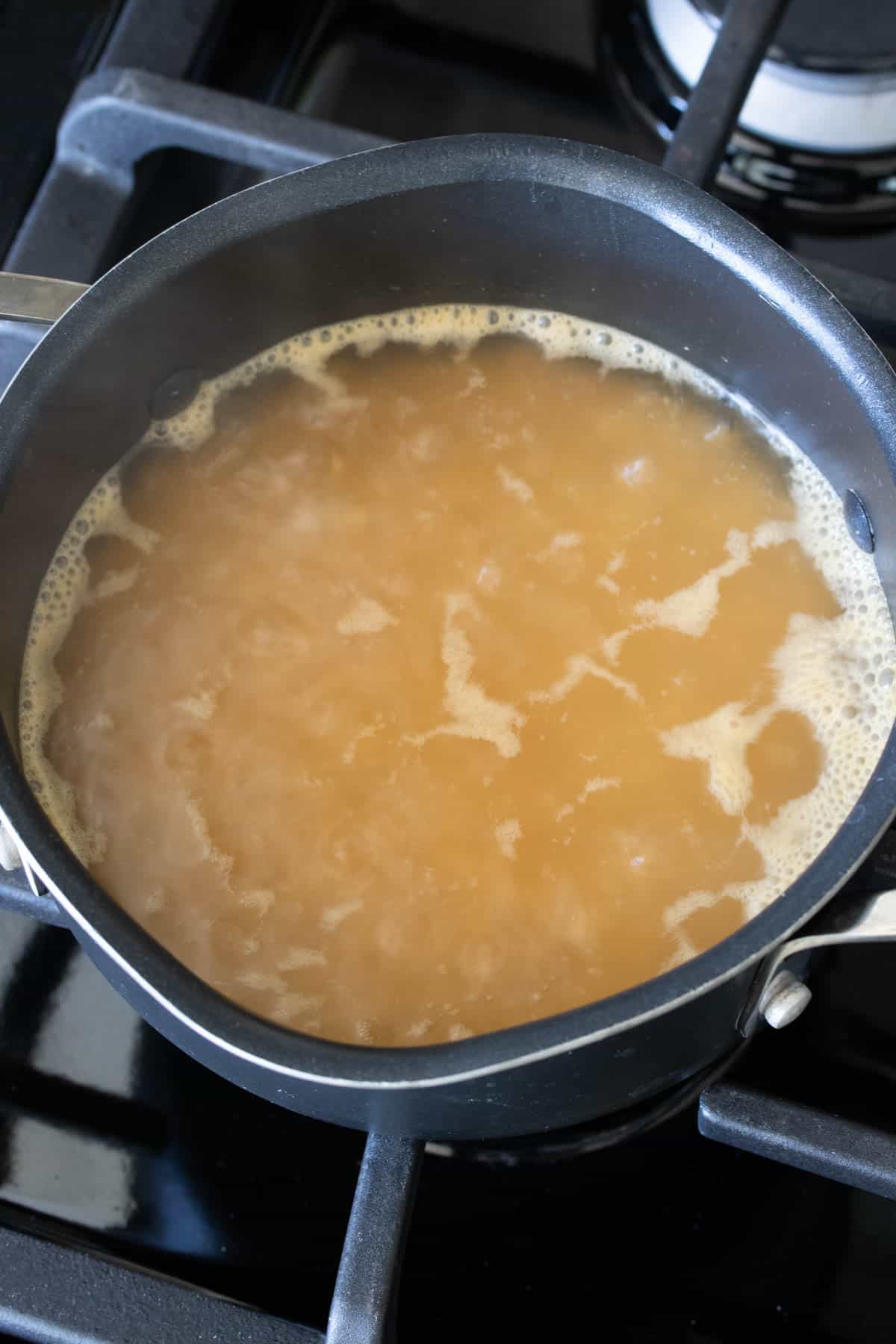 Pot with boiling broth and rice inside