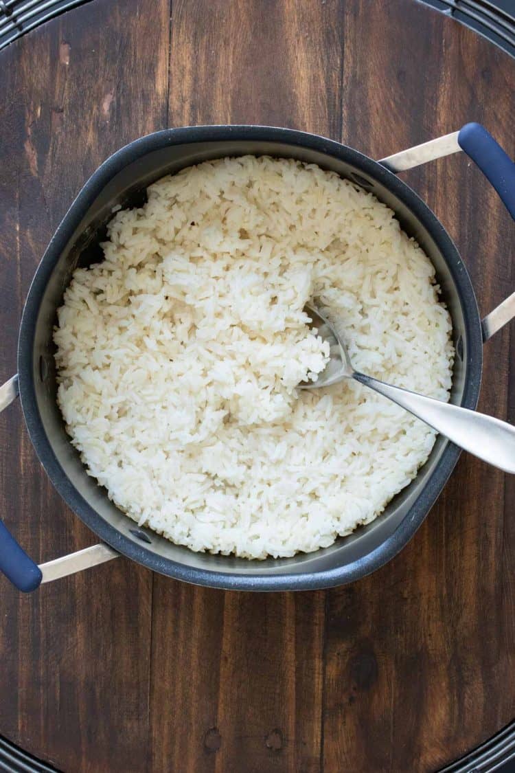 Spoon mixing white rice in a pot