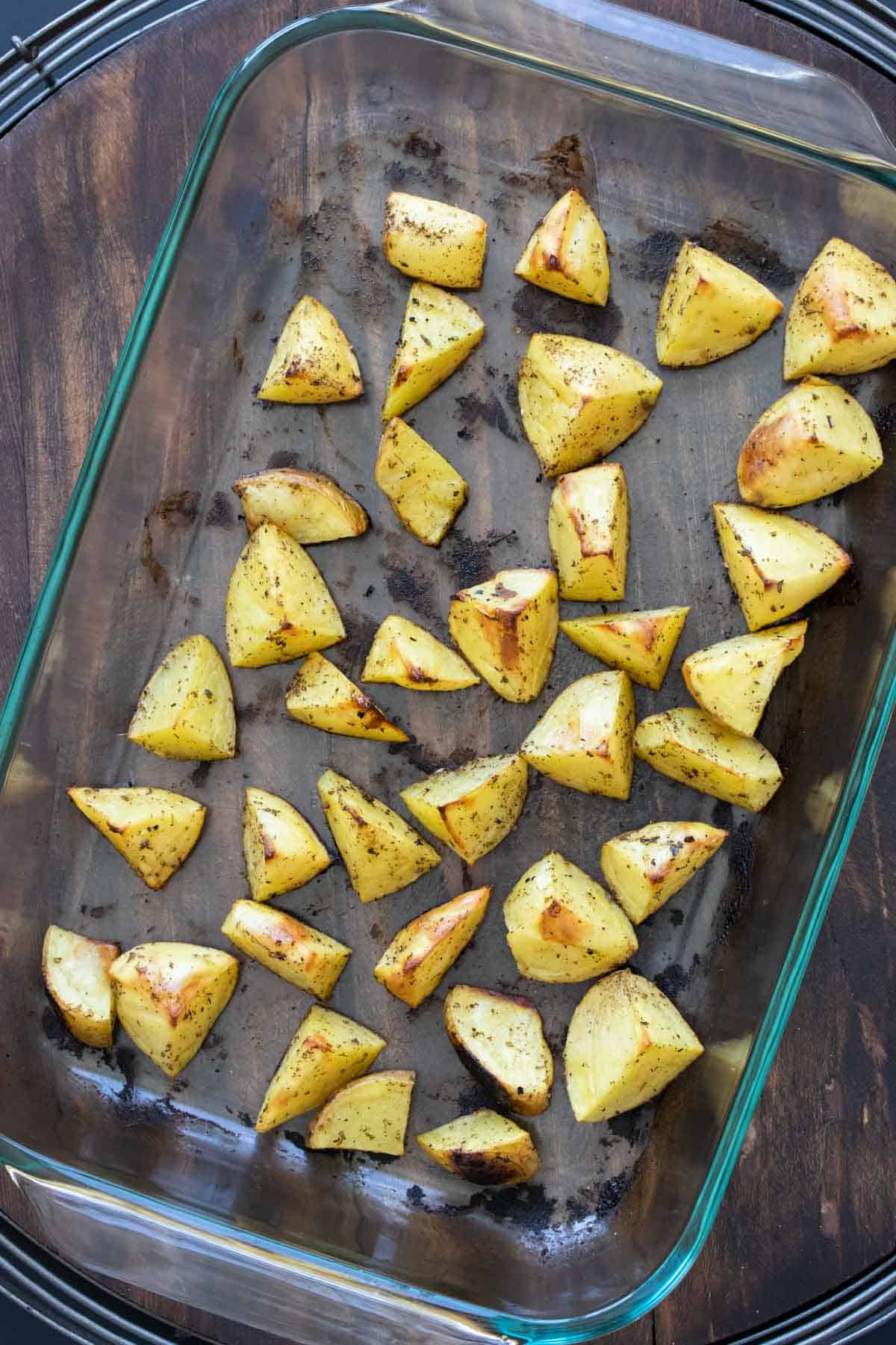 Baked crisp potatoes in a glass baking dish.