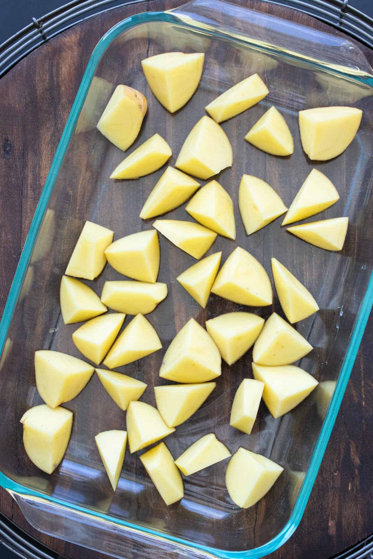 Cut potatoes in a glass baking dish.