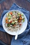 White plate with roasted veggies and pasta sprinkled with parmesan cheese