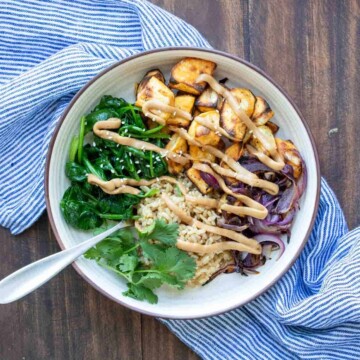 Fork in a cream bowl with rice, potatoes, spinach, onion and sauce