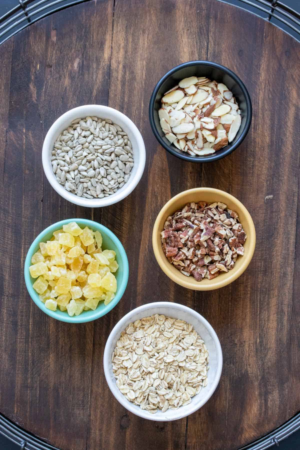 Different color bowls filled with ingredients to make homemade granola