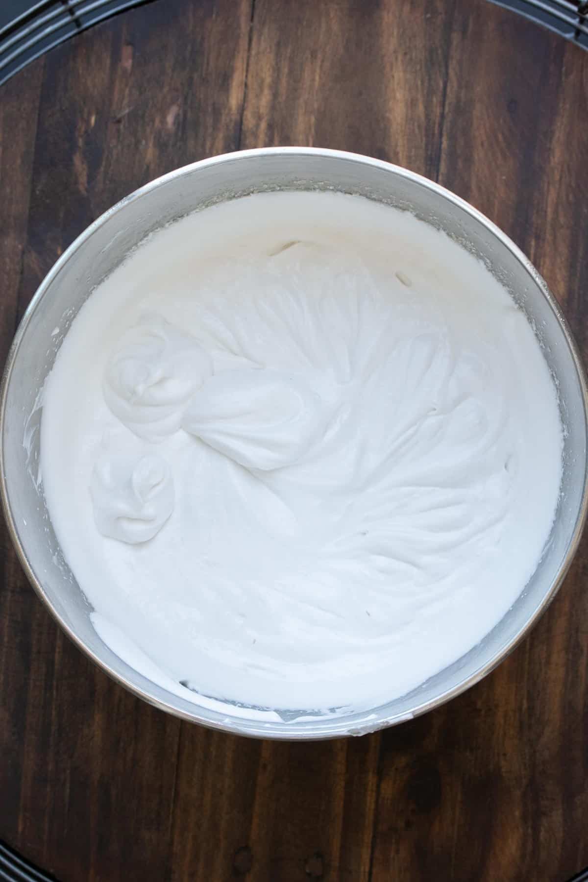 Top view of coconut whipped cream in a silver bowl.