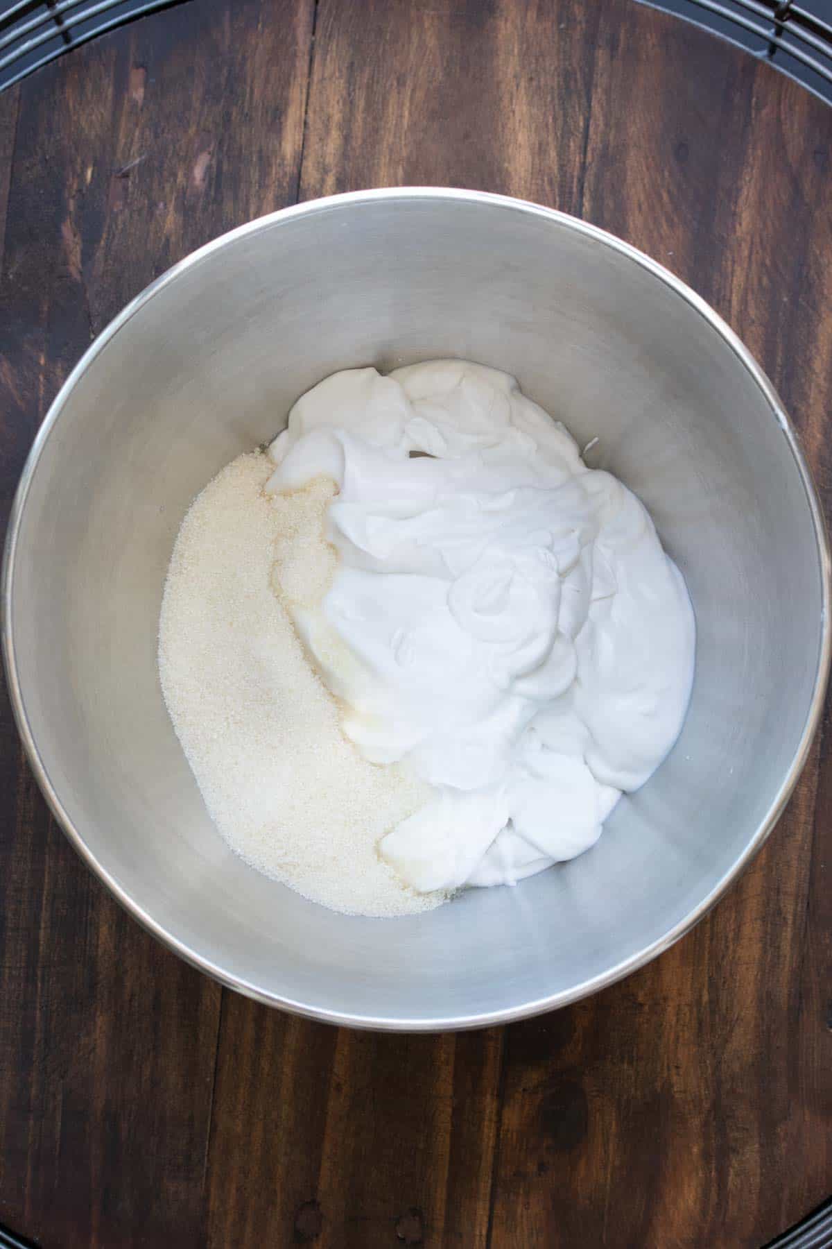 Silver bowl with sugar and coconut cream in it.