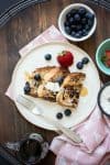 Overhead view of three pieces of French toast with berries next to them