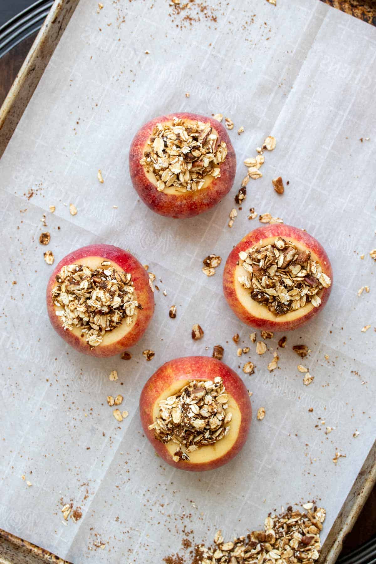 Four raw cored apples topped with an oat filling