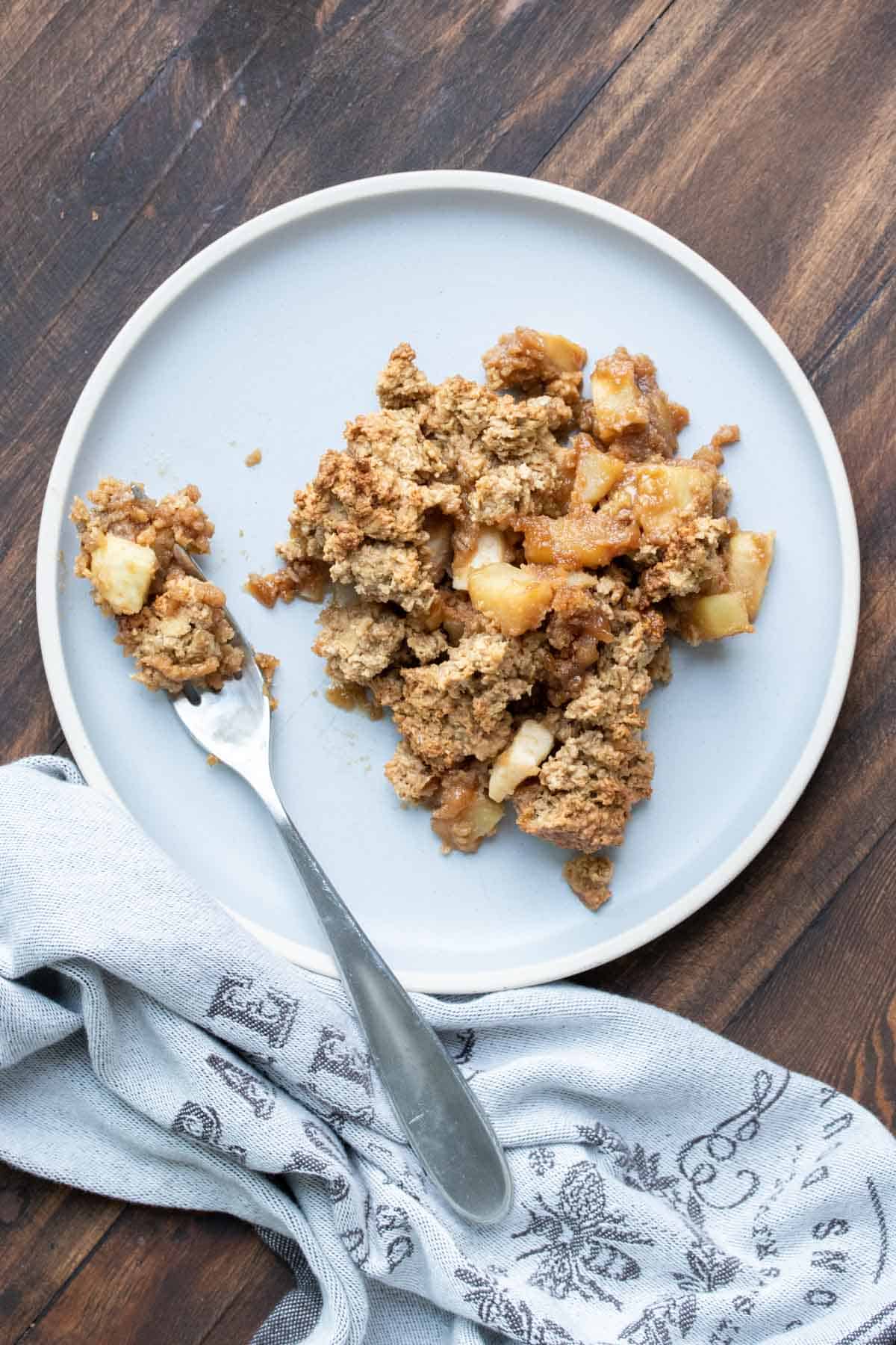 Fork on a grey plate with apple crisp.