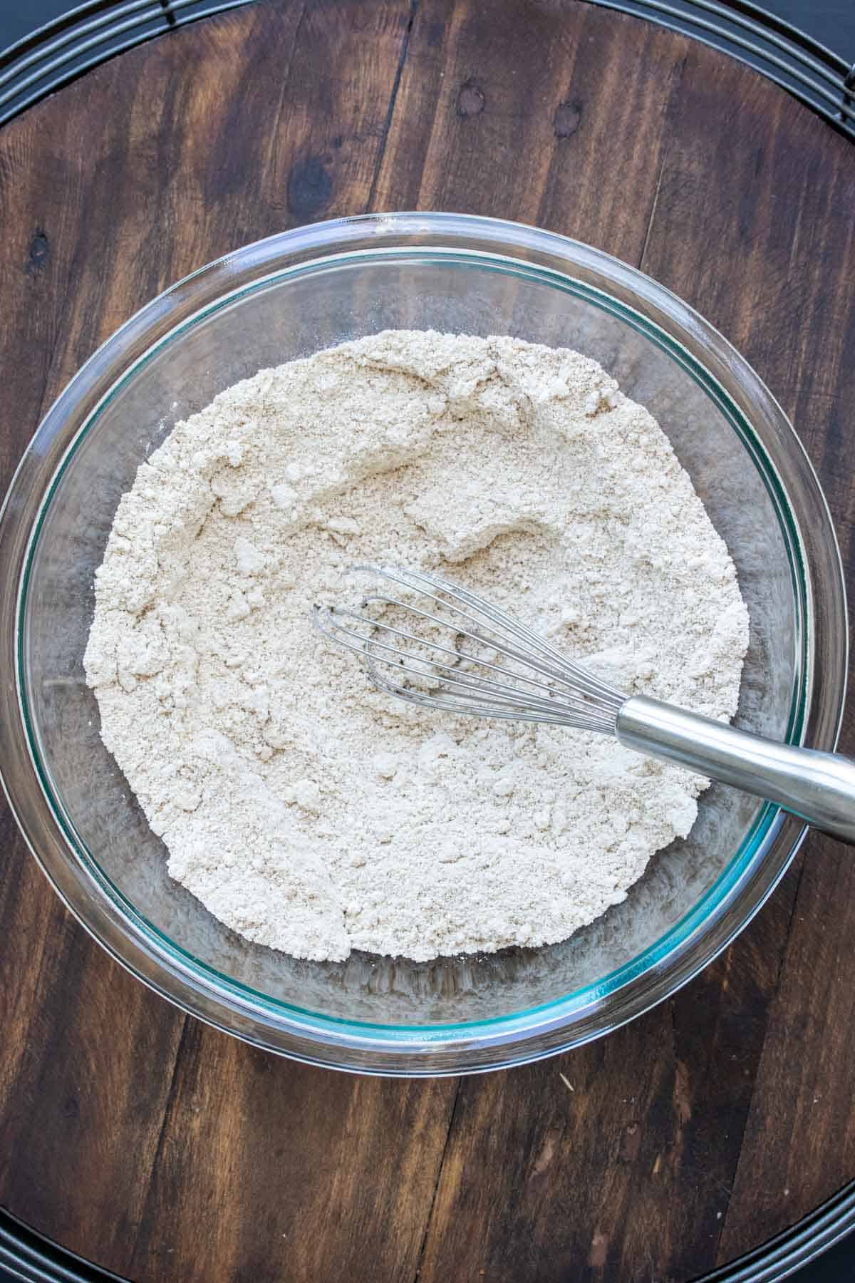 Top view of glass bowl with flour being whisked