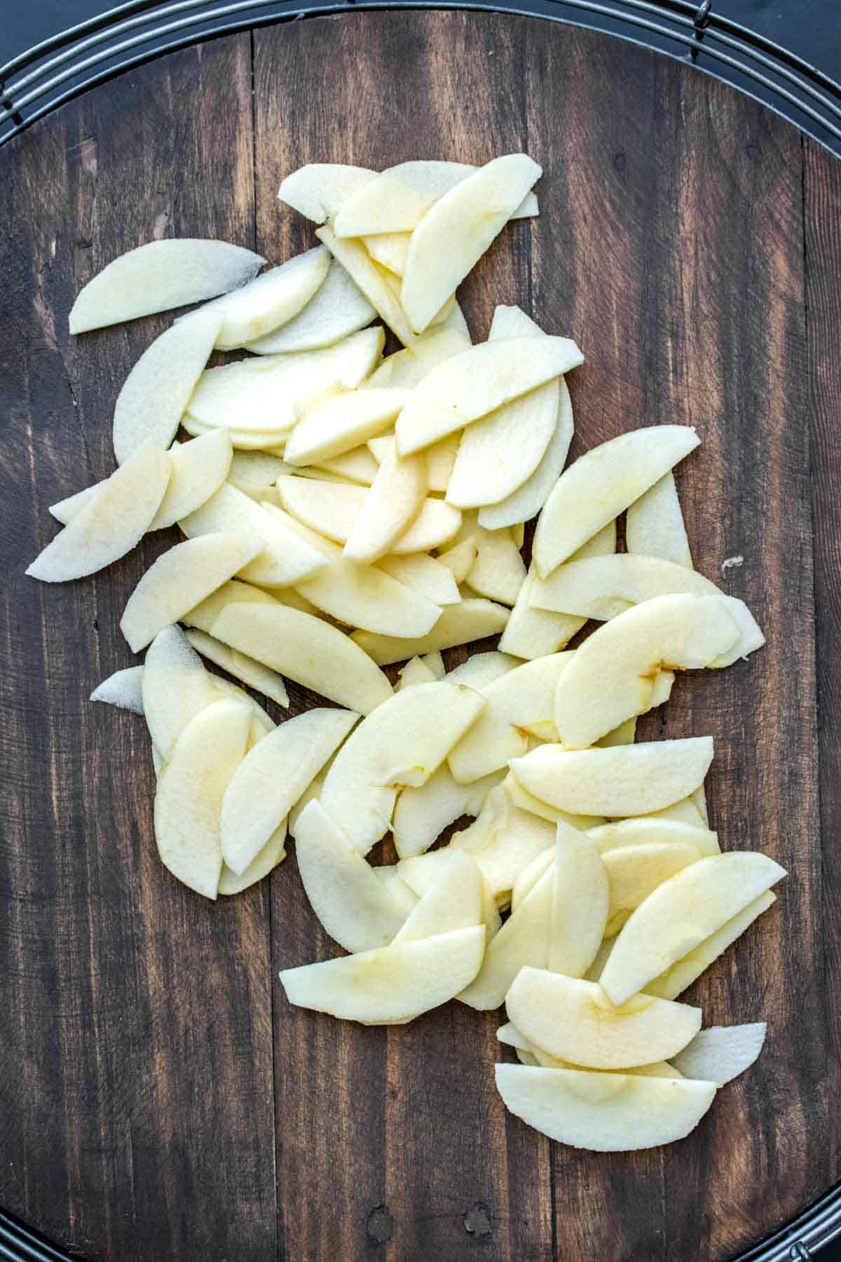 Peeled sliced apples on a wooden surface
