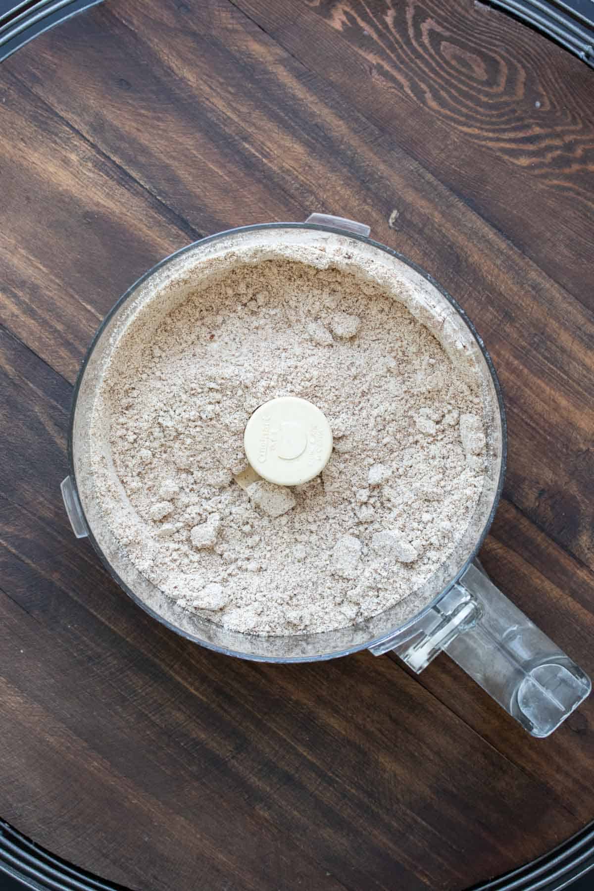 Top view of a food processor with a flour mixture inside